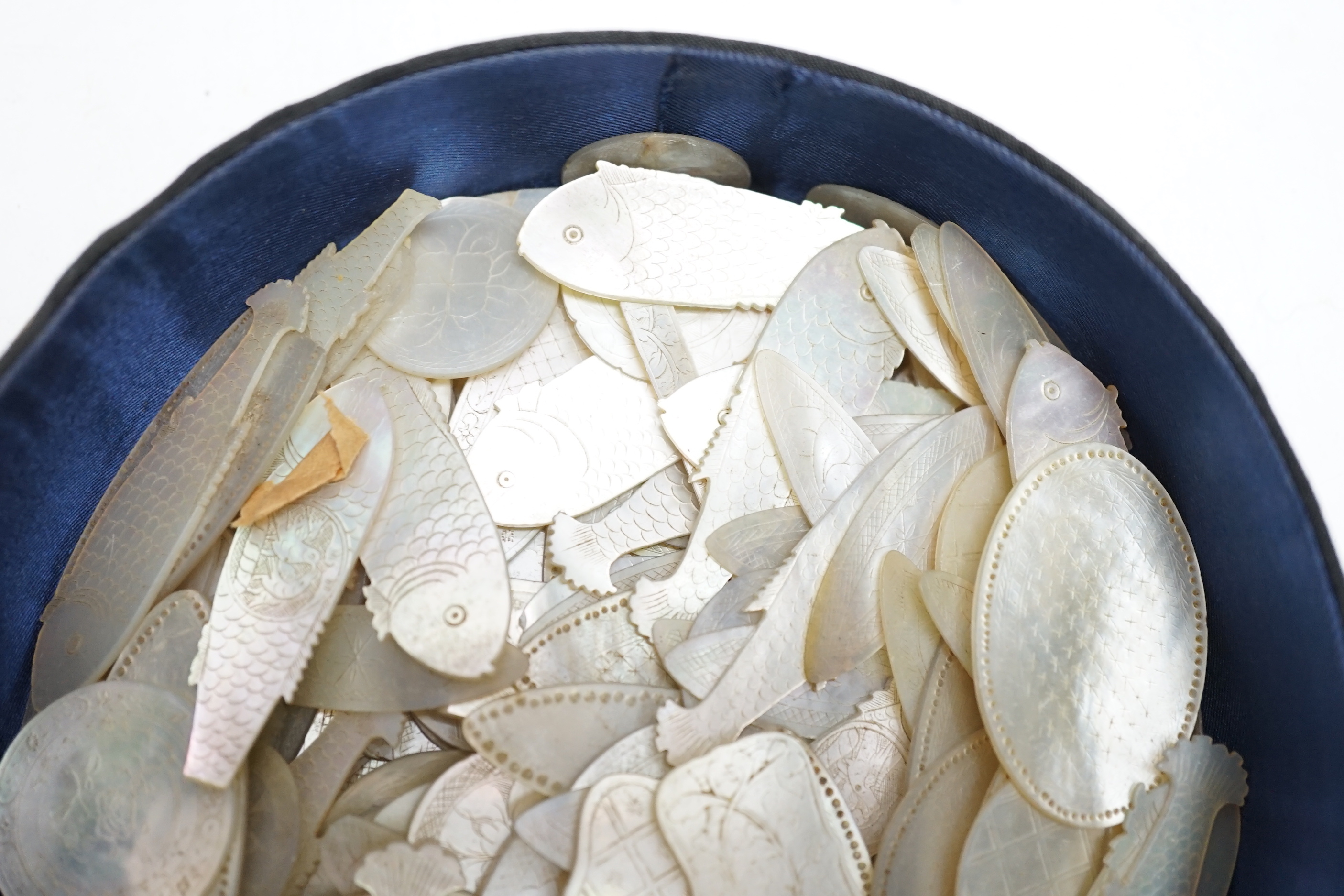 A collection of Chinese mother of pearl fish and other shaped counters